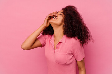 Young african american woman isolated on pink background laughing happy, carefree, natural emotion.