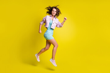 Fototapeta na wymiar Full length profile portrait charming cheerful girl running look camera isolated on yellow color background