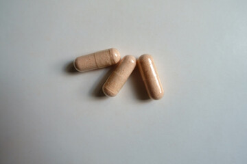 3 pink capsules of probiotic dietary supplement from above