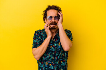 Young caucasian man wearing summer clothes isolated on yellow background whining and crying disconsolately.