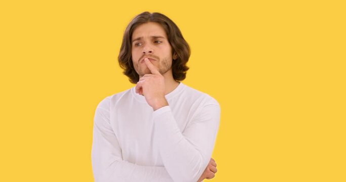Brainstorm concept. Studio shot of young pensive man pondering over solution, counting on fingers and keep thinking