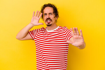 Fototapeta premium Young caucasian man isolated on yellow background being shocked due to an imminent danger