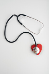 Stethoscope and red heart on white background. Health concept. Heart attack.