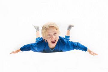 Scared little blond boy is falling from height. Free fall. White background
