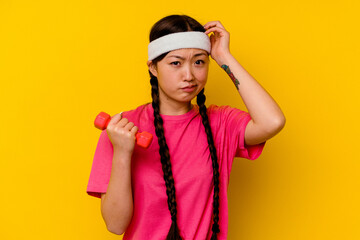 Fototapeta na wymiar Young sport chinese woman isolated on yellow background being shocked, she has remembered important meeting.