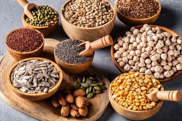 Assortment of beans, legumes on grey concrete background.