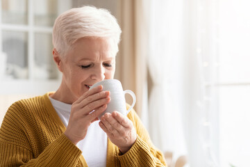 Closeup of senior woman drinking coffee or tea