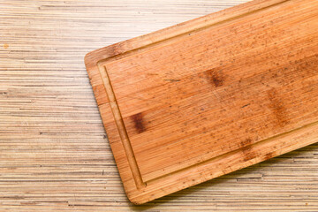 Old chopping board on wooden background top view