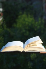 Open book in a garden. Selective focus.