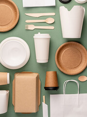 Eco friendly disposable tableware on green background