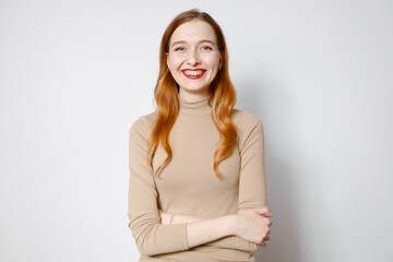 Fototapeta premium Portrait of a smiling red-haired woman. White background