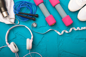 sport at home - white sneakers, dumbbells and jump rope, measurement tape, towel and water bottle, headphones