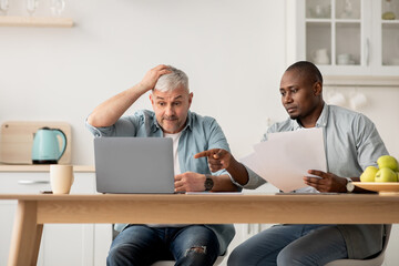 Managing home finance, reviewing bank account and using laptop, economic crisis