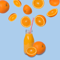 Creative idea made from fresh slices of orange floating in the air and going towards a bottle of juice on a light blue background