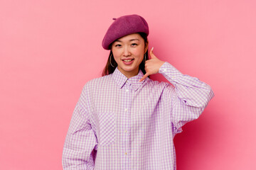 Young chinese woman isolated on pink background showing a mobile phone call gesture with fingers.