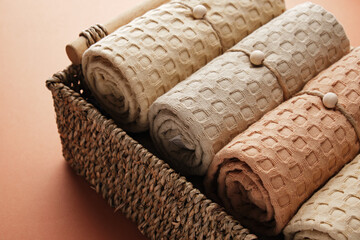 Collection of natural muslin bath towels in a wicker basket. Natural, soft, air and stylish home textiles. View from above.