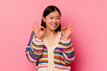 Young chinese woman isolated on pink background cheerful and confident showing ok gesture.