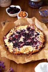 Blueberry, frangipane galette. Side view. Wooden background.
