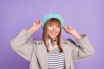 Photo of cute curious girl look empty space toothy smile wear blue beret coat isolated violet color background