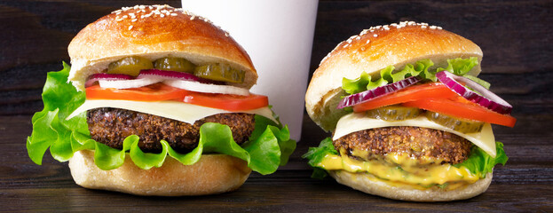 Cheeseburger and cup of coffee on a wooden background. Banner. Hamburger with cheese. Burger isolated. Tasty dinner
