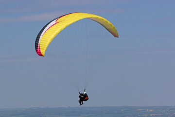 Tandem Paraglider flying wing in a blue sky	