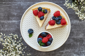 Cheesecake with berries on a grey wooden background. Top view.