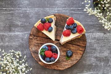 Cheesecake with berries on a grey wooden background. Top view.