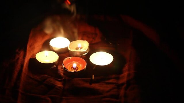 Candles are burning, incense sticks, smoke. Hands to drive over candles, smoke and fire