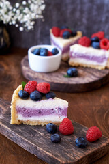 Cheesecake with berries on a wooden background. Side view.