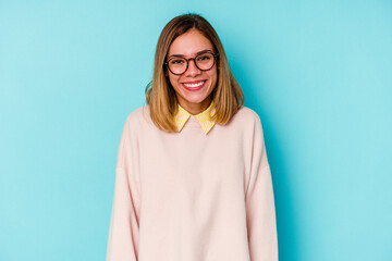 Fototapeta premium Young student caucasian woman isolated on blue background happy, smiling and cheerful.