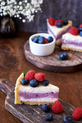 Cheesecake with berries on a wooden background. Side view.