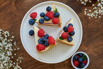 Cheesecake with berries on a wooden background. Top view.