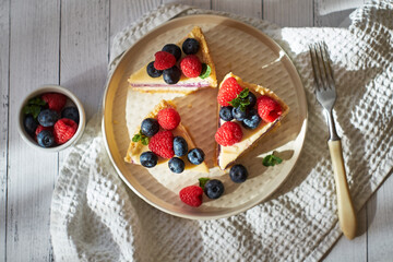 Cheesecake with berries on a white background. Side view.