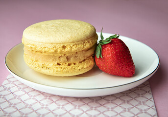 Colorful french macaron with delicious strawberry. Sweet confectionery, preparing a celebration cakes. on pink background