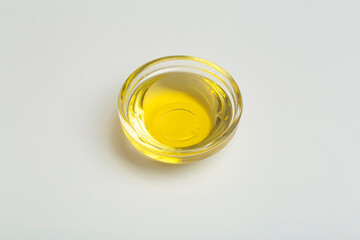 Vegetable oil isolate in a glass bowl. Yellow liquid vegetable oil on white blank background