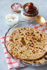 Indian traditional Hot Onion Paratha with yogurt. Indian onion stuffed Flatbread. also known as Pyaz ke parathe in Hindi. over a light background with copy space.