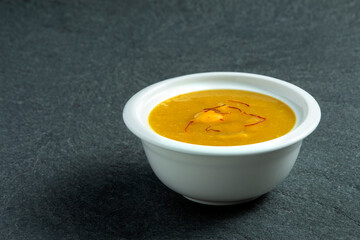 Aamras is plain Haapus or Alphonso Mango Puree/Pulp with kesar/ saffron topping. Aam Ras is a delicious Indian seasonal Dessert recipe. Served in a white bowl on white background