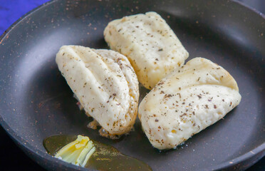 Halloumi cheese frying in grill pan.