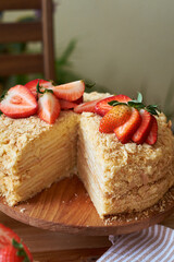 Napoleon cake with strawberries on a wooden background. Side view.