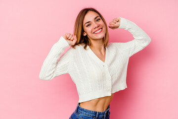 Young caucasian woman isolated on pink background stretching arms, relaxed position.