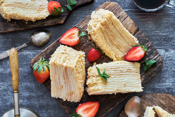 Napoleon cake with strawberries on a wooden background. Top view.