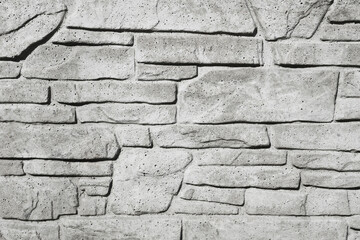 Gray house facade background. Gray brick wall texture. Decorative stone blocks structure. Grunge architecture pattern. Retro tile backdrop. Modern rock background.