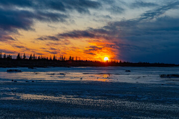 A dramatic orange winter sunset over Hudson Bay, Manitoba, Canada