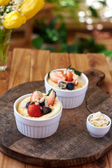 Souffle. Berries, cottage cheese, wooden background. Side view.