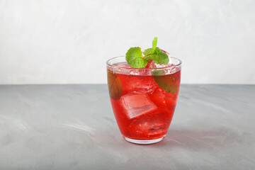 Red summer refreshing soft drink with ice or fruit iced tea. Close-up, gray background, copy space