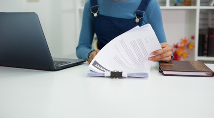 Female auditors work with documents at their desks in the office.