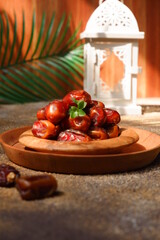 dates fruit in a wooden plate against brown background