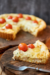 Tart with cheese, tomatoes and fish. Side view.