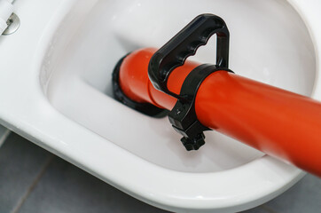 Professional force pump cleaner in toilet bowl.
