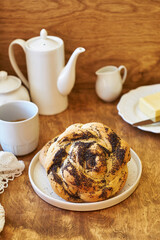 Brioche with cane sugar and poppy seeds on a wooden background. Bun. Top view.